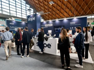 Stand Slope al TTG Travel Experience, con operatori alberghieri e professionisti del turismo durante una sessione di networking e presentazione della piattaforma.